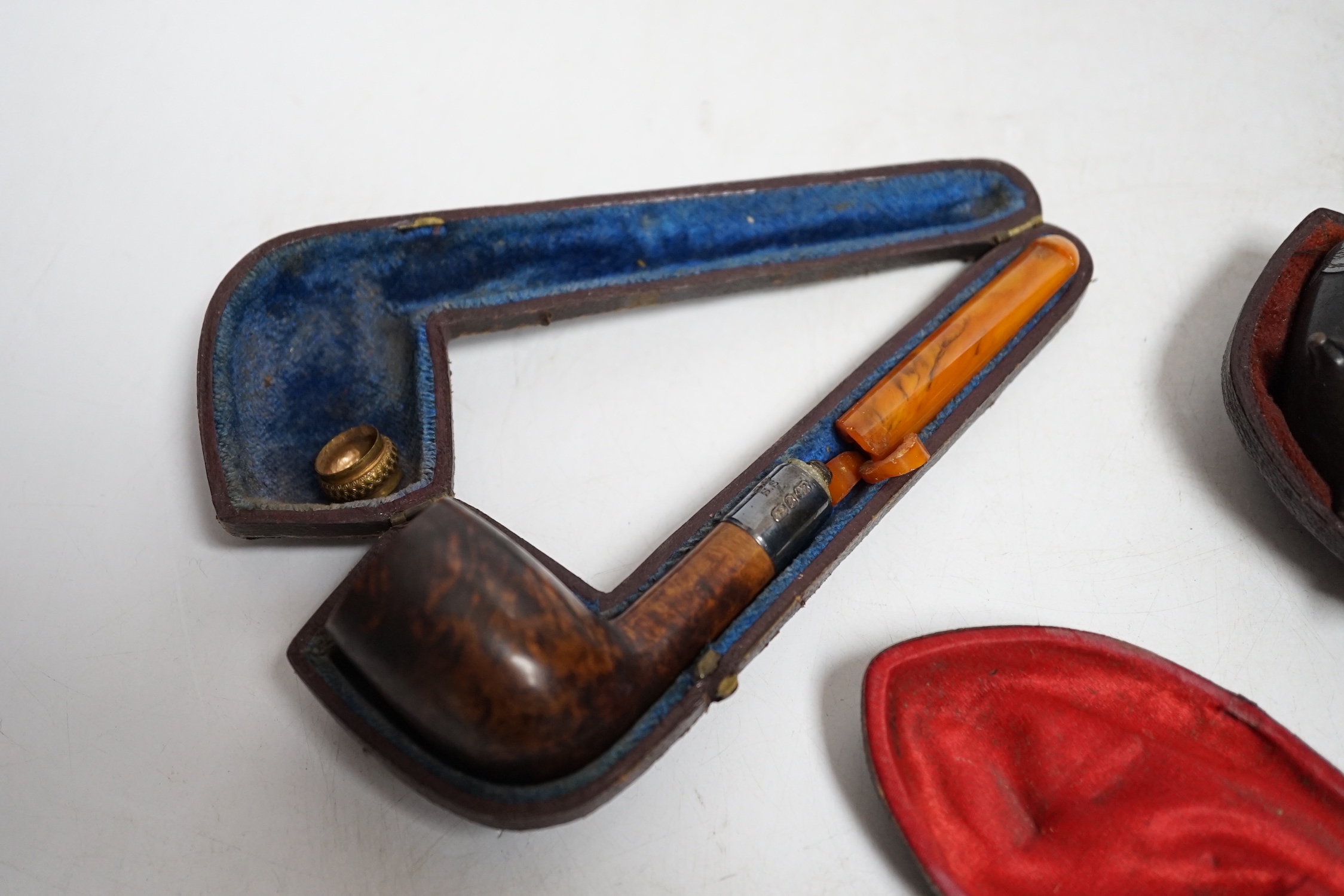 Three cased pipes, one with carved amber novelty bowl, the other two with amber pipe ends, metal mounted, together with a tortoiseshell and mother of pearl card case, Card case 10.5cm high x 8cm wide